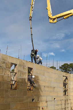 Workmen hosing off the excess concrete on the dacart walls. 