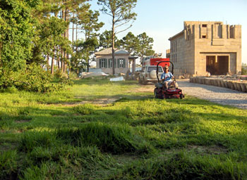 Dave Perry cutting the grass after cornice blocks are moved.